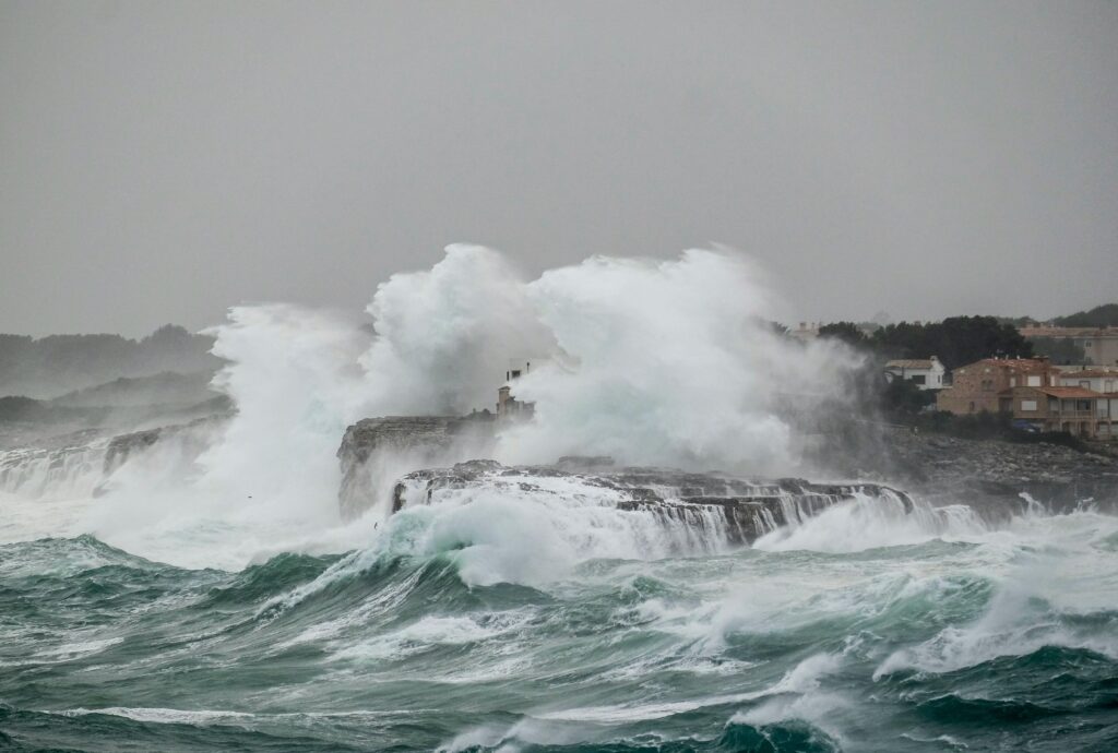 Powerful waves crash against the rocky shoreline in Portocolom, capturing the essence of nature's fury.