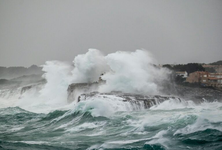 Powerful waves crash against the rocky shoreline in Portocolom, capturing the essence of nature's fury.